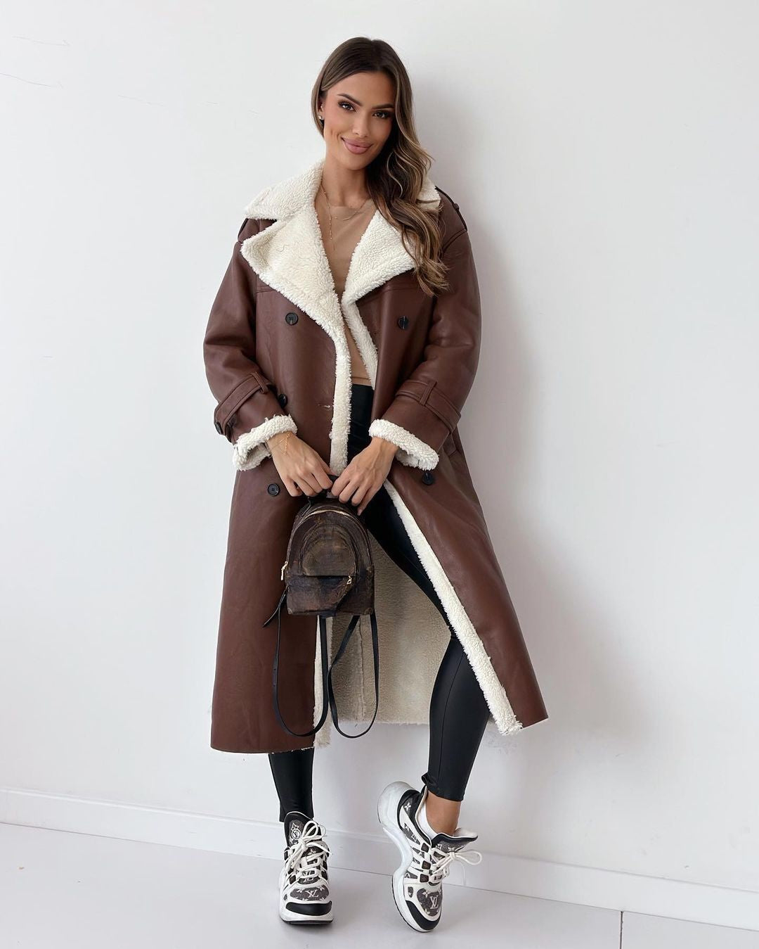 Side view of the brown double-breasted teddy coat with cream shearling lining