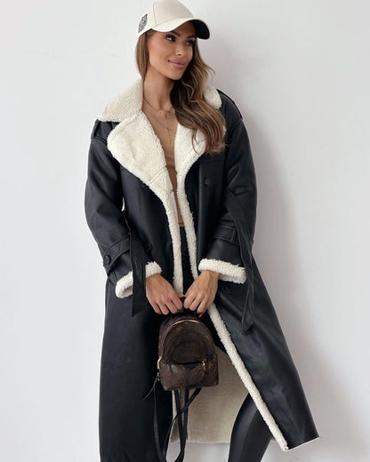 Full-length view of the black teddy coat styled with a cap and shoulder bag