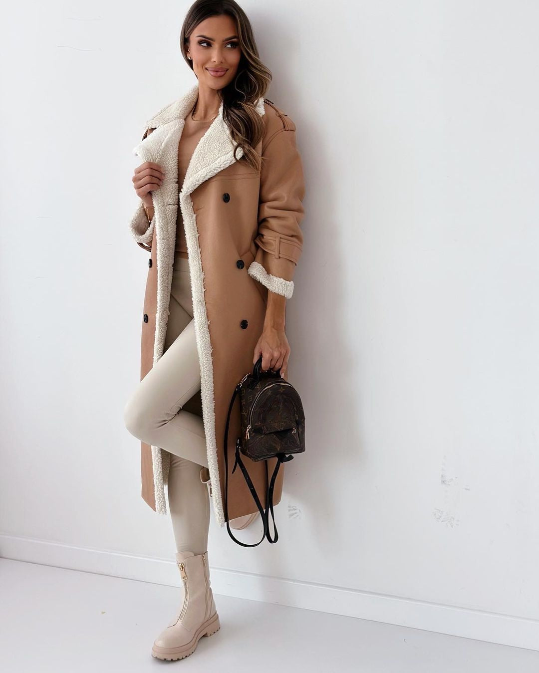 Full-length view of the khaki teddy coat styled with cream trousers and ankle boots