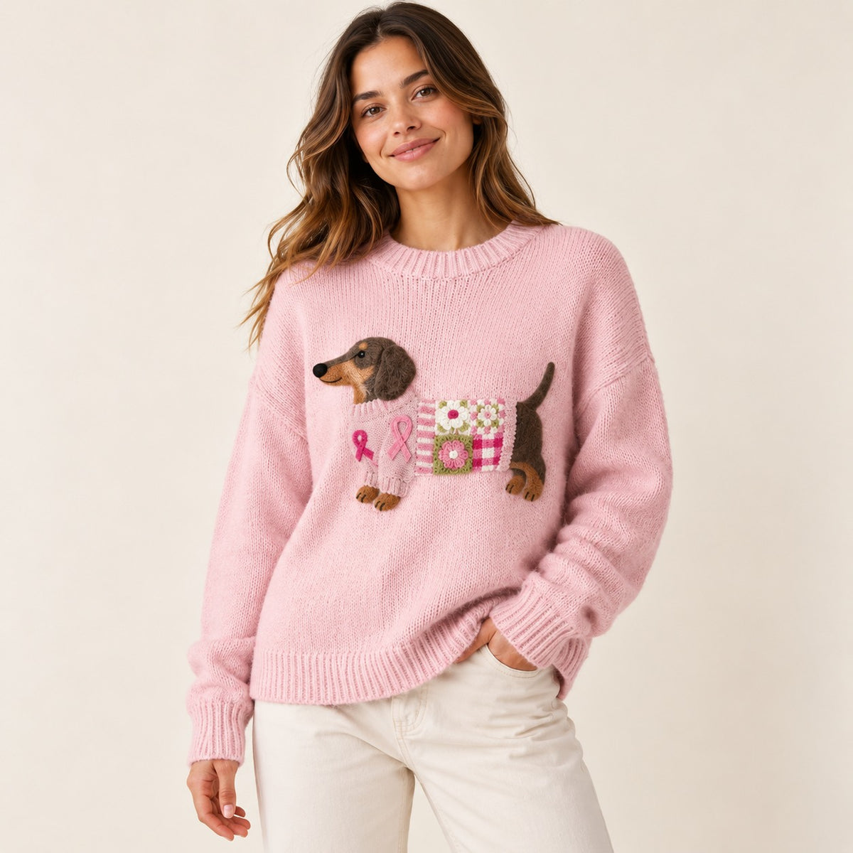 Woman wearing a pink knit sweater with an embroidered dachshund motif