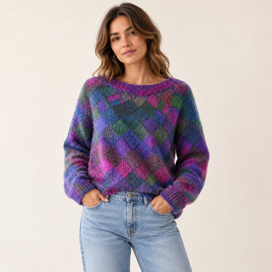 Woman wearing a purple and pink diamond-pattern knit sweater with light blue jeans