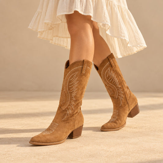 Tan embroidered suede cowboy boots with block heel, worn with a cream midi skirt