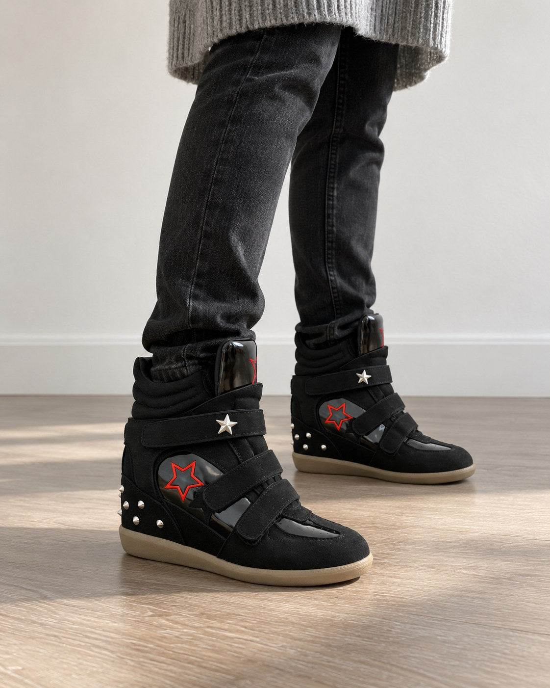 Black studded star wedge sneakers with red star panel, styled with dark jeans and a grey knit