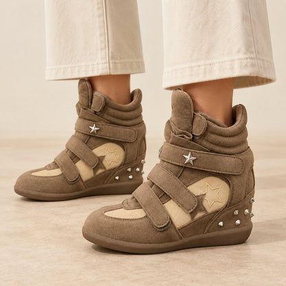 Khaki studded star high-top wedge sneakers with silver star studs, worn with cream wide-leg trousers
